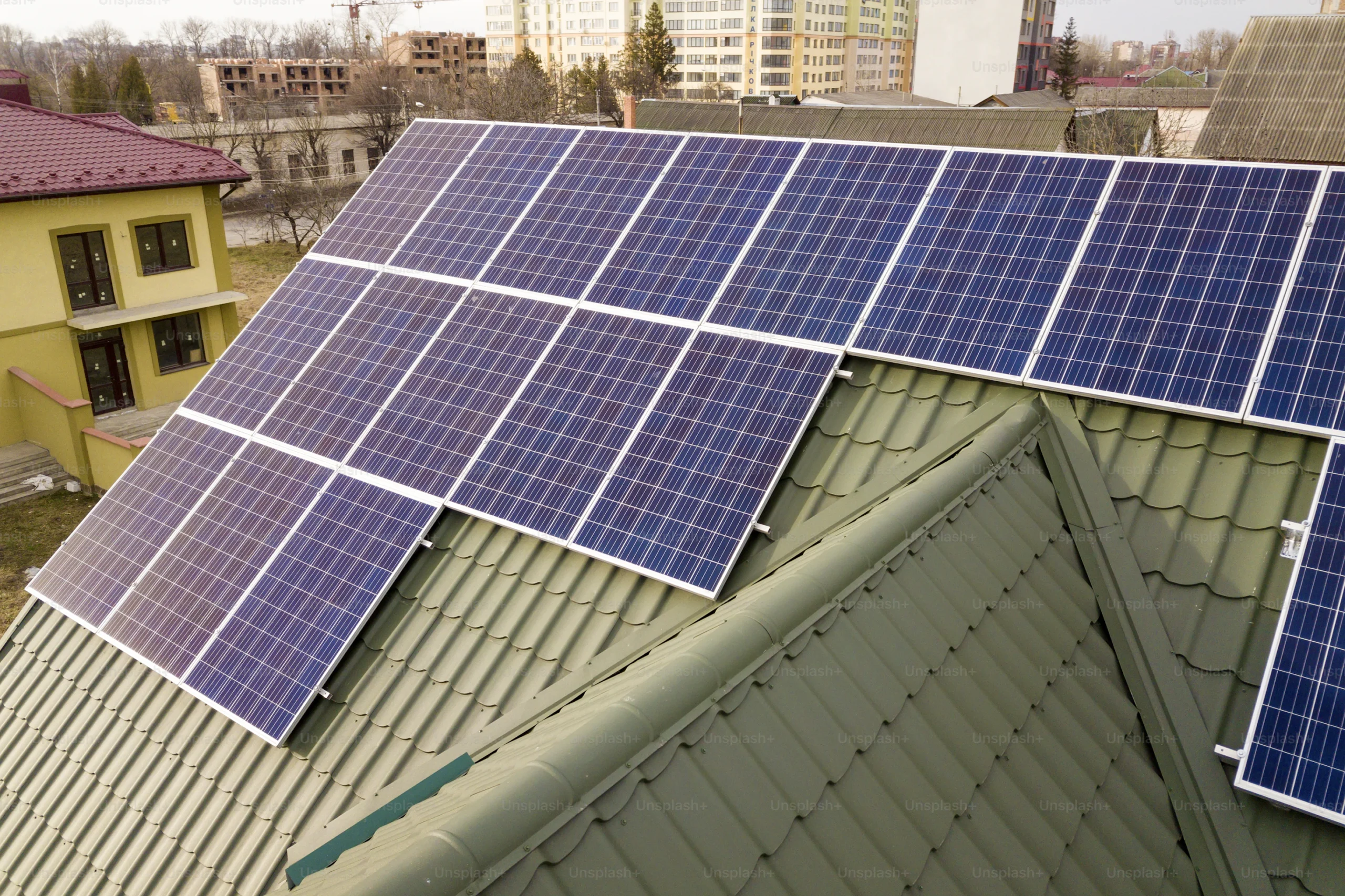 Blue solar panels on green metal roof