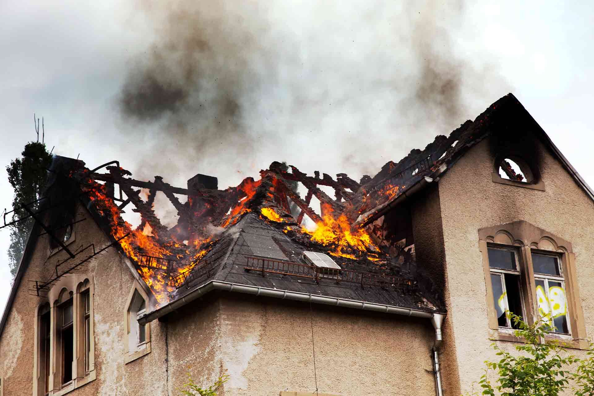 ground view of roof of a home on fire